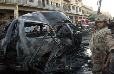 
Iraqi soldiers on Wednesday secure the Baghdad site where a suicide bomber lured a crowd of day workers with the promise of jobs, then detonated his explosives-packed van. 
 (Associated Press photos / The Spokesman-Review)