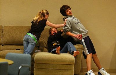 
From left, Stacie Davis, 13, and Annie Millard, 12, attempt to keep Nick Clark, 13, off the couch as the three horse around before a youth group event  at The Outlet Youth Center Wednesday.
 (Liz Kishimoto / The Spokesman-Review)