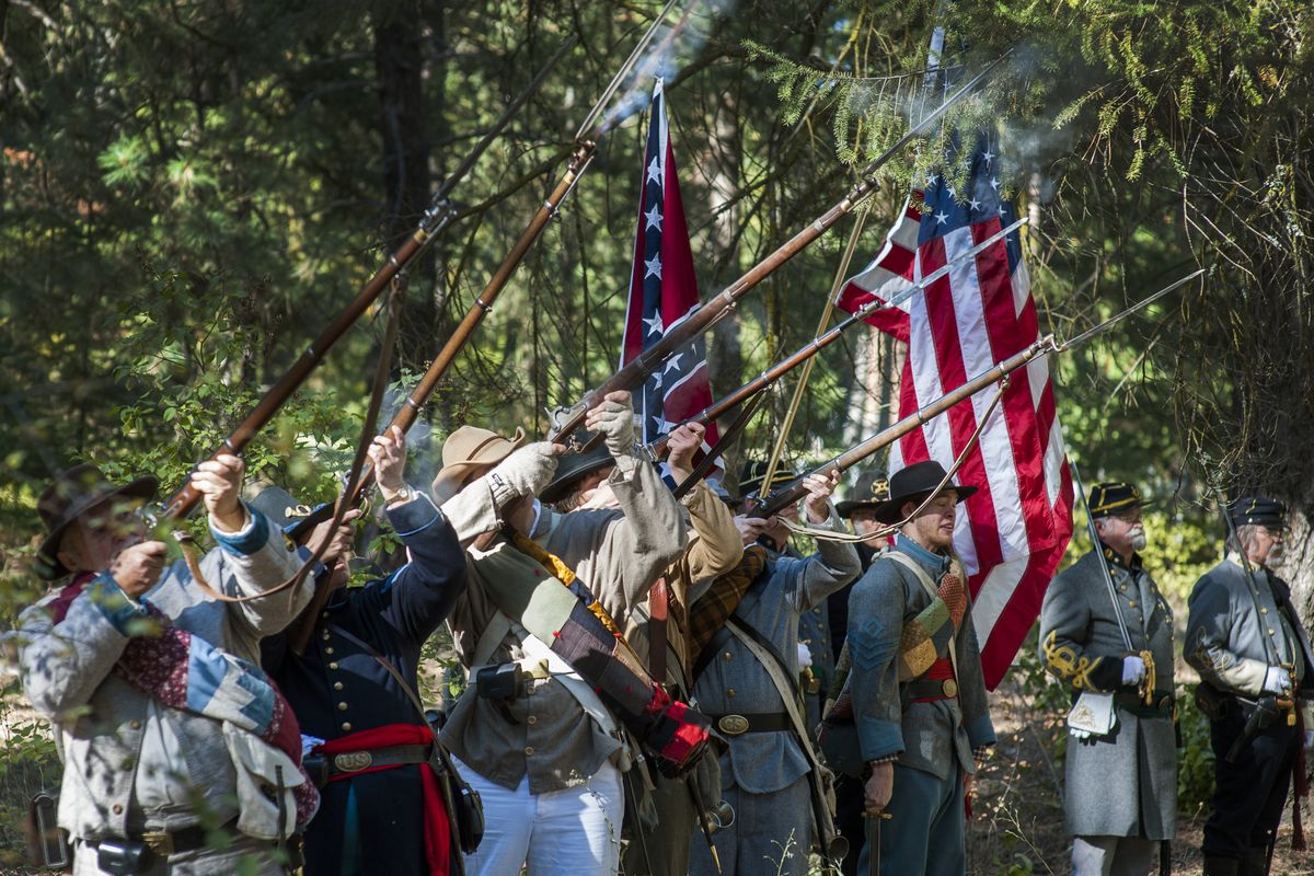 An honor guard made up of Confederate and Union Civil War re-enactors fires a salute during the dedication of the final resting place of Confederate soldier Pvt. Hugh McLaughlin in Greenwood Memorial Terrace cemetery on Saturday. (PHOTOS BY COLIN MULVANY)