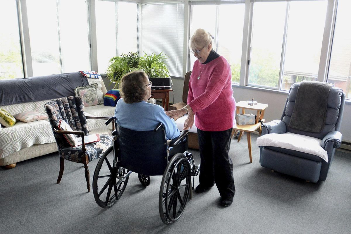 ADVANCE FOR USE SUNDAY, JUNE 25 - In this June 1, 2017 photo, Sister Clarissa Goeckner, right, visits with Sister Cecile Marie Uhlorn at the Monastery of St. Gertrude near Cottonwood, Idaho, where Sr. Clarissa is being cared for by her fellow Benedictine sisters. Looking at a photo album is a welcome trip through her past. (Barry Kough /Lewiston Tribune via AP, File) ORG XMIT: IDLEW101 (Barry Kough / AP)