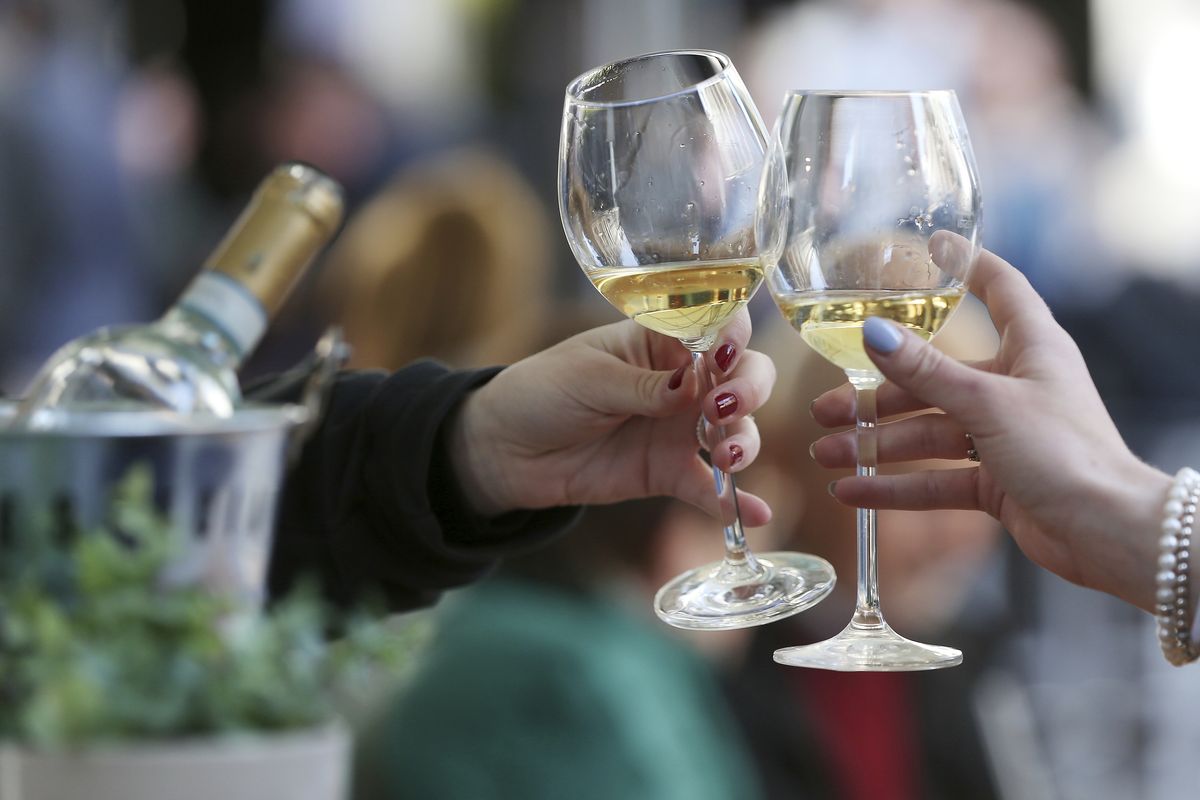 Women toast with white wine at a table in the outdoor area of a restaurant, in Duesseldorf, Germany, Friday, May 21, 2021. After months of forced break, restaurateurs in Duesseldorf are allowed to welcome guests again as of Friday. As in other municipalities in North Rhine-Westphalia, this only applies to the outdoor area and under certain coronavirus measures.  (David Young)