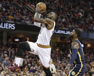 Cleveland’s LeBron James, left, drives to the basket against Indiana’s Paul George during Sunday’s game. The Cavaliers won 135-130 in double overtime. (Tony Dejak / Associated Press)