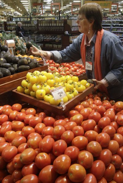 Connie Booth picks out an avocado while shopping at a Kroger Co. supermarket in Cincinnati. Many economists expect food prices to keep rising through the end of the year. (Associated Press)