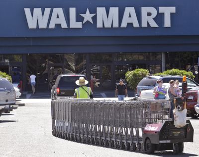 A Wal-Mart worker pulls carts at a Wal-Mart store in Pittsburg, Calif., on Monday. A worker at this store was a plaintiff in a sex- discrimination class-action lawsuit against Wal-Mart. (Associated Press)