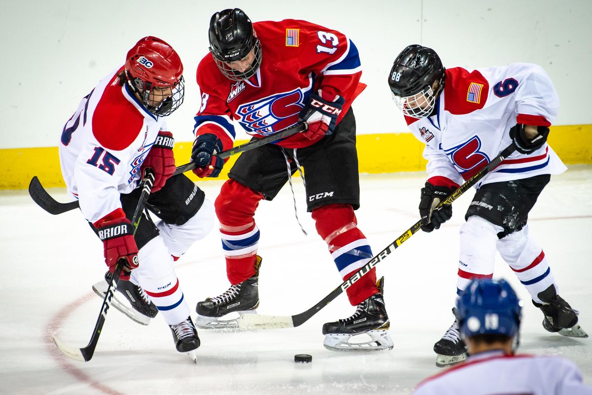 Linden Makow (15), Carson Buydens (13) and Garrett Brown (6) vie for posession of the puck during the Spokane Chiefs