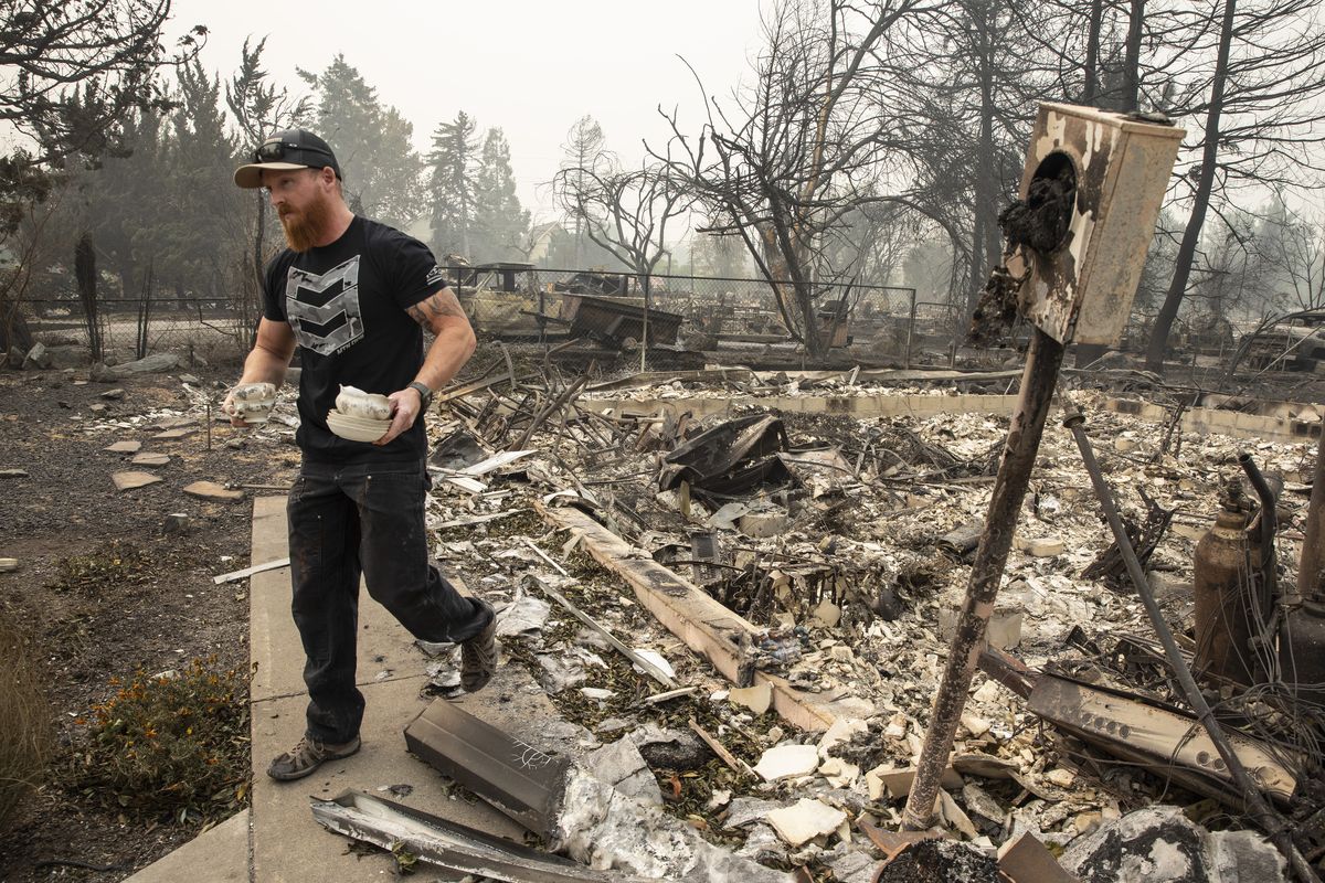 Derek Trenton from Talent, Ore. salvages some items at his parents home as wildfires devastate the region, Friday, Sept. 11, 2020 in Talent, Ore.  (Paula Bronstein)