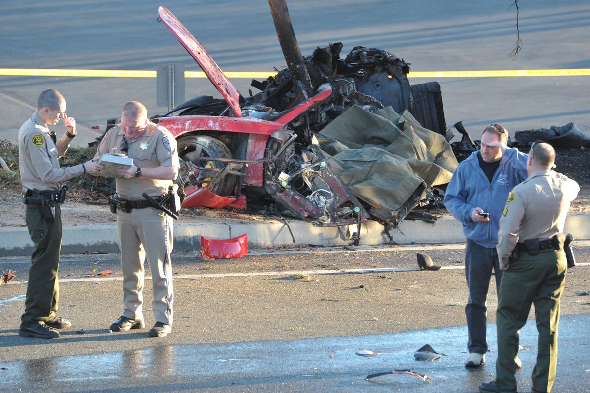 Sheriff’s deputies work near the wreckage of a Porsche sports car – in which actor Paul Walker was riding – that crashed into a light pole in Valencia, Calif., on Saturday. (Associated Press)