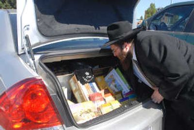 
Rabbi Levi Slonim organizes literature on Judaism, which he keeps in his trunk, on Tuesday on Coeur d'Alene.
 (Jesse Tinsley / The Spokesman-Review)