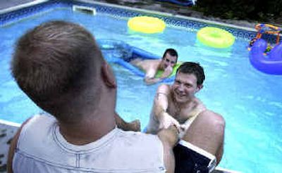 
Ryan Oelrich, 23, tries to pull Lance Kissler, 22, into the pool on Saturday evening at a Quest Youth Group pool party. Oelrich started the group with a $50,000 grant to counsel young gay and bisexual males. 
 (Jed Conklin / The Spokesman-Review)