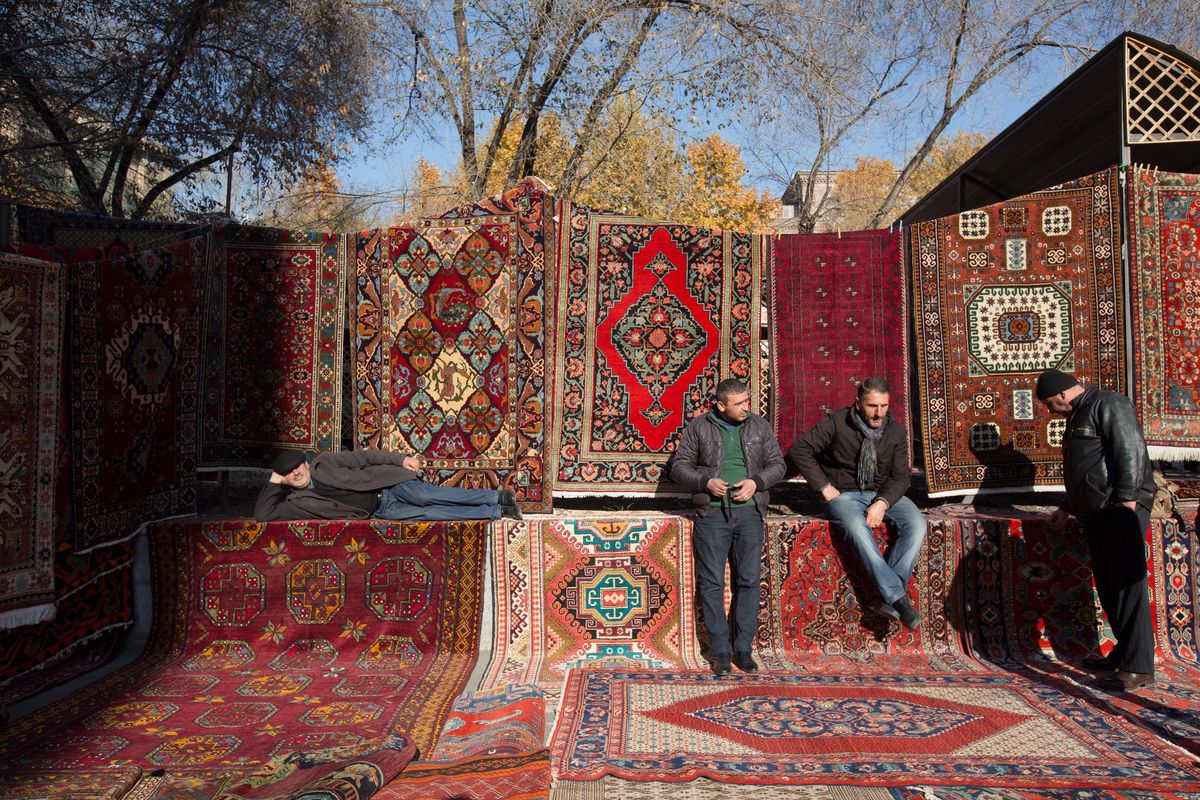 Vendors wait for customers at a patterned rug and carpet store at the Vernissage open-air market in Yerevan, Armenia, on Nov. 19, 2016. (Andrey Rudakov / Andrey Rudakov/Bloomberg)