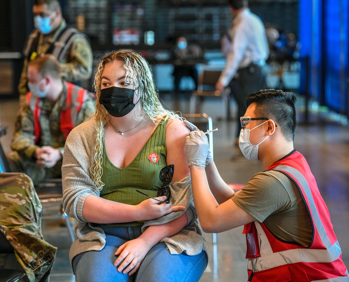 Bailey Dunlap, 21, receives her first Moderna vaccination from Wendell Tu of the Army National Guard on April 2 at the Spokane Arena. (DAN PELLE/THE SPOKESMAN-REVIEW)