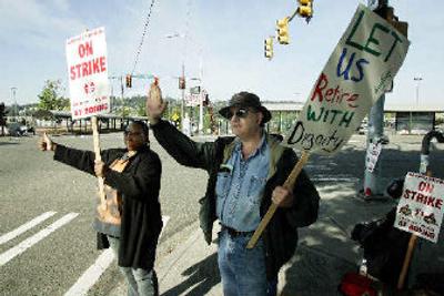 
Striking Boeing Co. workers Jackie Vaden, left, a wire assembler from Seattle, and Mark Bentler, a machine tool repairman from Issaquah, Wash., wave at passing cars as they picket Tuesday.  
 (Associated Press / The Spokesman-Review)