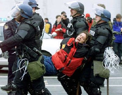 
Seattle police officers carry away a demonstrator detained during World Trade Organization street protests in 1999. Trade ministers hope Hong Kong, where they gather for next week's World Trade Organization meeting, won't repeat the scenes in Seattle.  
 (Associated Press / The Spokesman-Review)