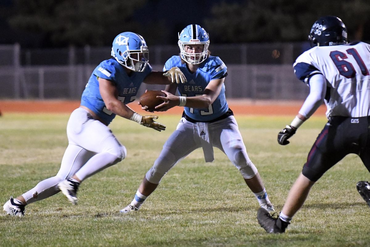 Central Valley quarterback Matt Gabbert, center, hands off to runningback Hunter Chodorowski, left, as Mt. Spokane’s Matt McNitt, right, approaches Friday, Sept. 21, 2018. (Jesse Tinsley / The Spokesman-Review)