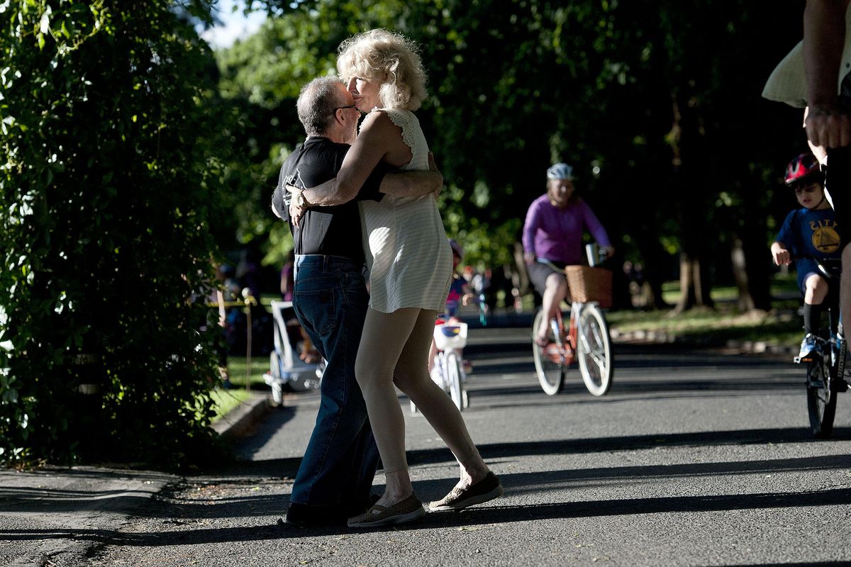 Ann Marie Burk dances the tango with Barry Satin during a break from biking with the Spokane Summer Parkways bikers on Wednesday, June 21, 2017. (Kathy Plonka / The Spokesman-Review)