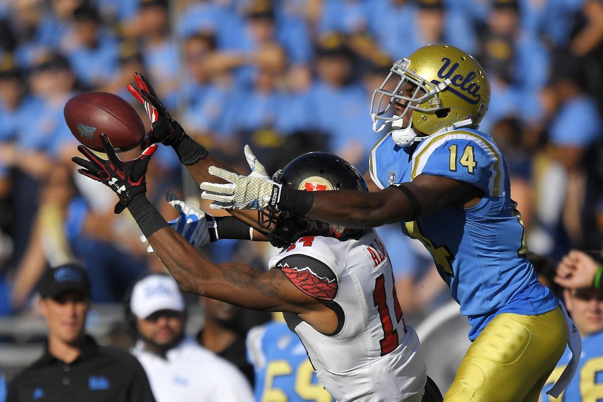 Utah defensive back Brian Allen, left, intercepts a pass intended for UCLA wide receiver Theo Howard during the second half of Saturday’s game in Pasadena, Calif. (Mark J. Terrill / Associated Press)