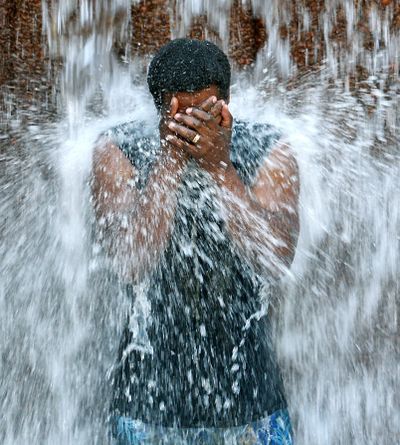 Taking a splash: Venique Lamy cools off in a fountain in Portland, where temperatures exceeded 90 degrees on Saturday. (Associated Press)