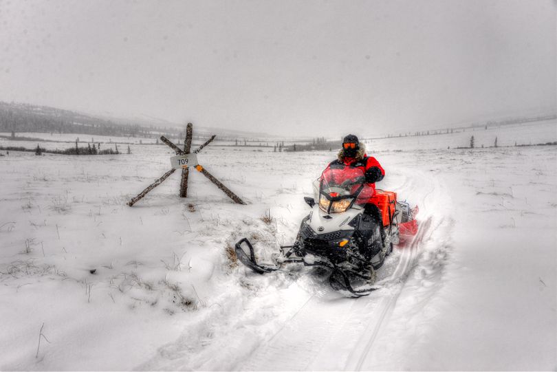 Bundled for the bitter cold, Josh Rindal of Spokane passes the Mile 709 marker on the historic portion of Alaska's Iditarod Trail between Unalakleet and Shaktoolik during his 1,400 mile snowmobile trek from Anchorage to Nome with Bob Jones of Kettle Falls. (Robert Jones)