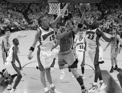 
Utah Jazz's Carlos Boozer shoots between Warriors Andris Biedrins, left, and Jason Richardson. 
 (Associated Press / The Spokesman-Review)