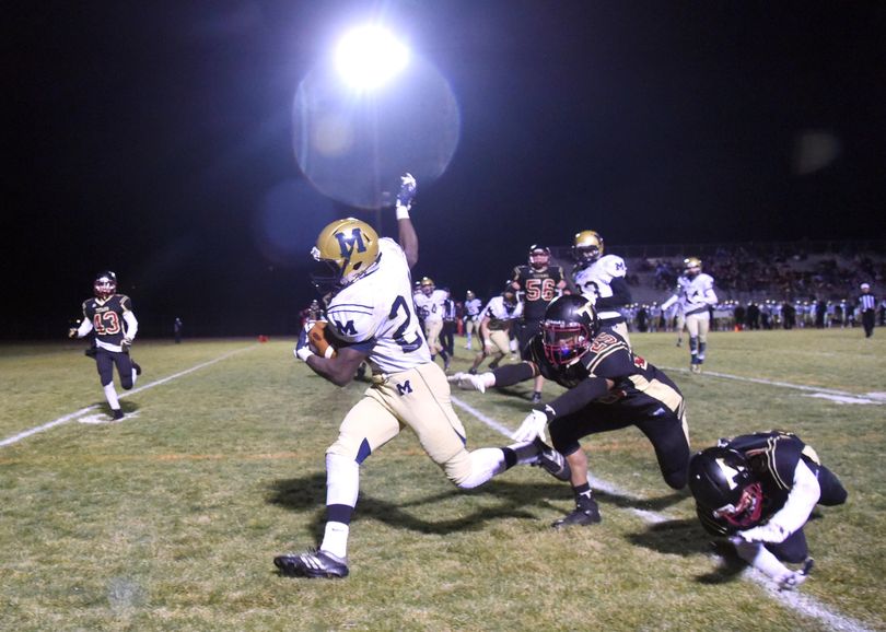 Mead's E.J. Bade, left, eludes University High defenders and darts into the endzone in the second half, Friday, Oct. 23, 2015, at University High School. (Jesse Tinsley / The Spokesman-Review)