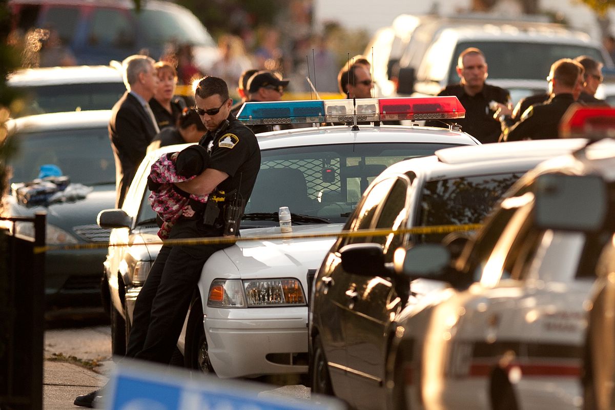 Rancho Cordova Sheriff officer holds a child that was unharmed in the triple homicide on De Soto Way in Rancho Cordova, Calif., on Tuesday afternoon, Oct. 23, 2012. Sacramento County Sheriff