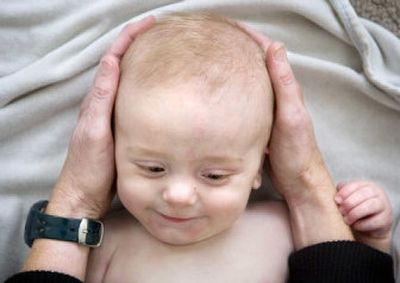 
Six-month-old Noah Holden smiles as his grandmother, Jane Bonogofski, cradles his head in her hands to see if he's ready for a massage Thursday morning. Kim Harmson, owner of In Touch, was teaching Bonogofski infant massage.
 (Holly Pickett / The Spokesman-Review)