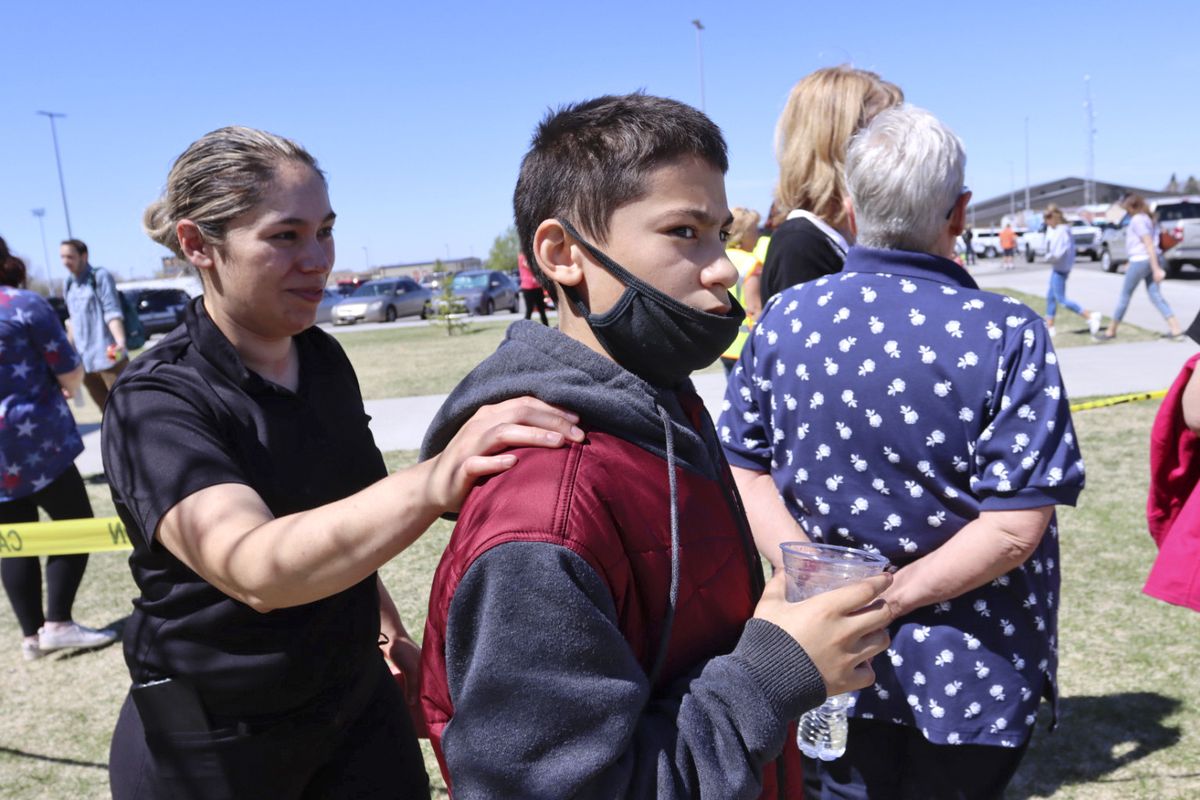 RETRANSMISSION TO CORRECT FIRST NAME TO ADELA - Adela Rodriguez, left, walks with her son, Yandel Rodriguez, 12, at the high school where people were evacuated after a shooting at the nearby Rigby Middle School earlier Thursday, May 6, 2021, in Rigby, Idaho. Authorities said that two students and a custodian were injured, and a male student has been taken into custody.  (Natalie Behring)