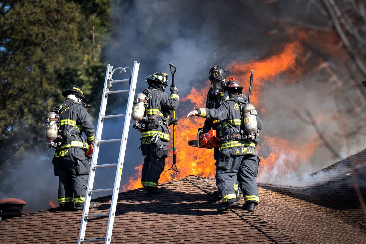 Firefighters from Spokane District 8 and the Spokane Fire Department battle a garage and house fire Wednesday on the 6600 block of S. Regal Road.  (COLIN MULVANY/THE SPOKESMAN-REVIEW)