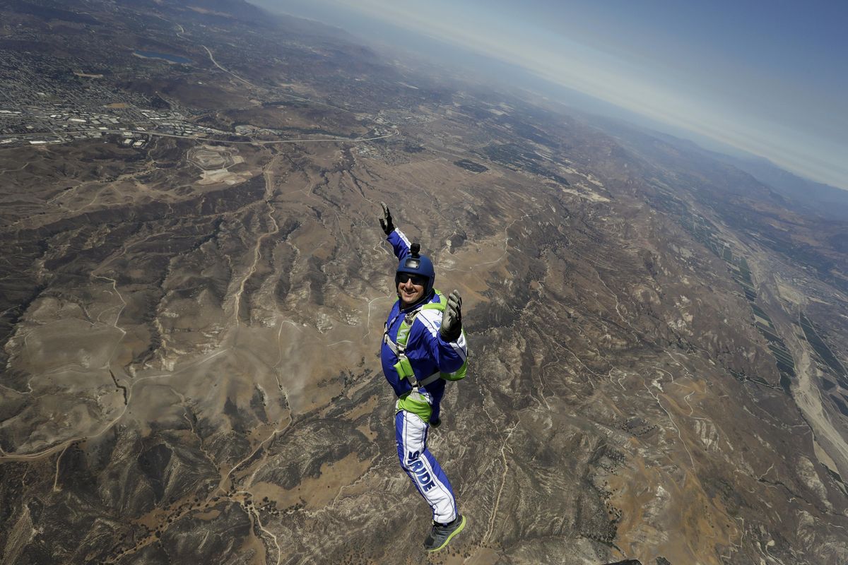 In this Monday, July 25, 2016 photo, skydiver Luke Aikins smiles as he jumps from a helicopter during his training in Simi Valley, California. After months of training, on July 30 this elite skydiver left his chute in the plane and bailed out 25,000 feet above Simi Valley into a 100 x 100 net with no parachute, no wingsuit and no fellow skydiver with an extra one to hand him in mid-air. (Jae C. Hong / Associated Press)