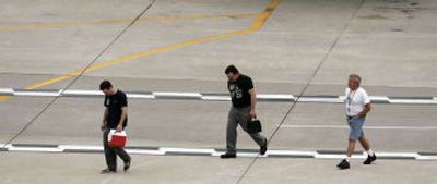
Men identified by striking Northwest Airlines mechanics as replacement workers walk on the tarmac after working on a Northwest Airlines jet on Saturday at Detroit Metropolitan Airport in Romulus, Mich. 
 (Associated Press / The Spokesman-Review)