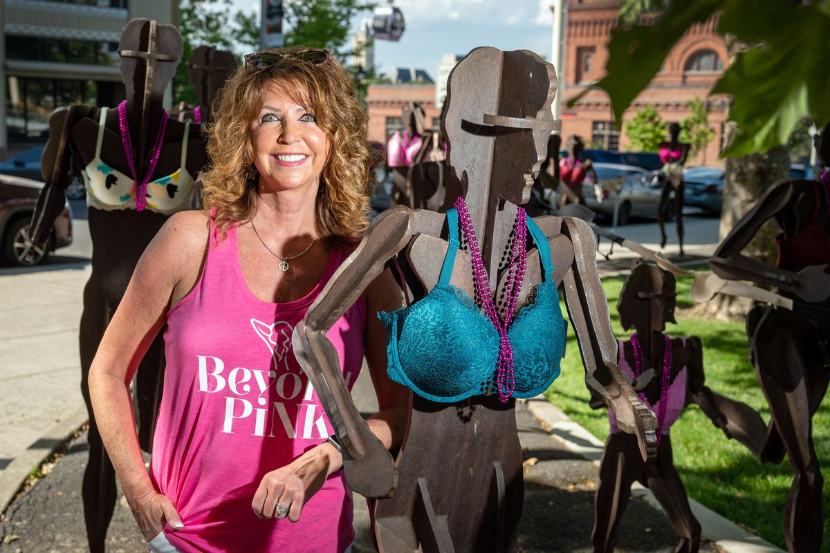 Charlie Brewer, co-founder of Beyond Pink, with helpers, dressed the Bloomsday runners statues in bras to honor women who have succumbed to or are fighting breast cancer Tuesday. Beyond Pink’s mission is to bring awareness to lifesaving breast thermal imaging and it ability to detect breast disease early.  (COLIN MULVANY/THE SPOKESMAN-REVIEW)