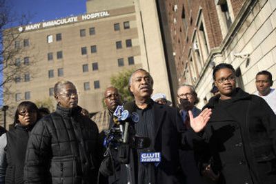 
The Rev. Al Sharpton, center,  expresses anger about  a police shooting that killed one man and injured two as he stands with relatives of the victims Saturday  outside  Mary Immaculate Hospital  in  New York. 
 (Associated Press / The Spokesman-Review)