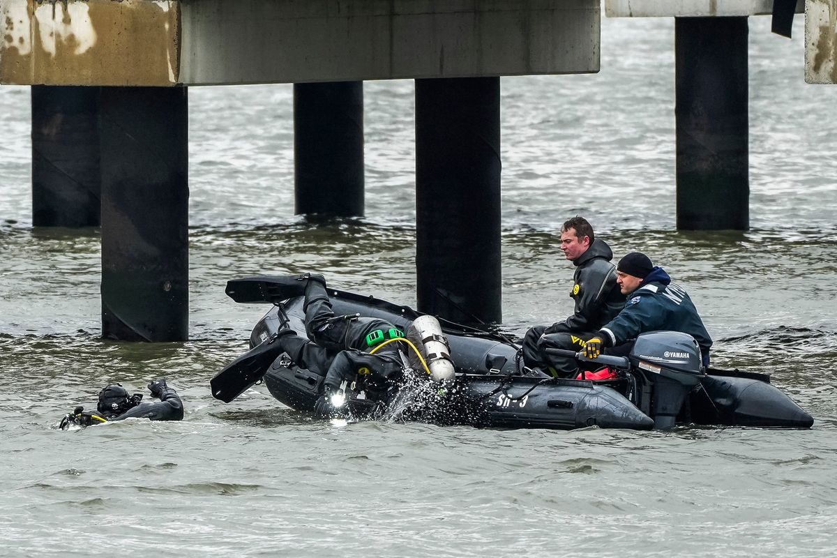 NYPD scuba divers team search next to the site of a crashed helicopter on Friday on the Hudson River in Jersey City, N.J. Six people are dead after the sightseeing helicopter carrying a family of tourists from Spain crashed into the Hudson River off Lower Manhattan. (Eduardo Munoz Alvarez)