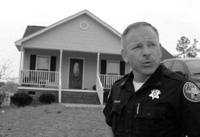 
Lexington County Deputy Sheriff Jon Shokes speaks about having to give foreclosure notices to people who are behind in their house payments, after serving notice to a house in Lexington County, S.C. 
 (Associated Press / The Spokesman-Review)