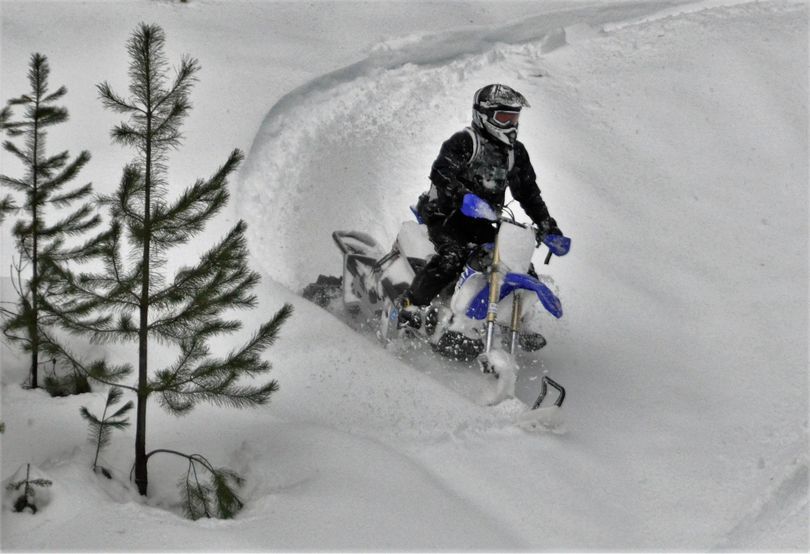 Ryan Porter of Priest Lake Powersports rides his snow cycle off a slope above Priest Lake, Idaho. (Rich Landers / The Spokesman-Review)