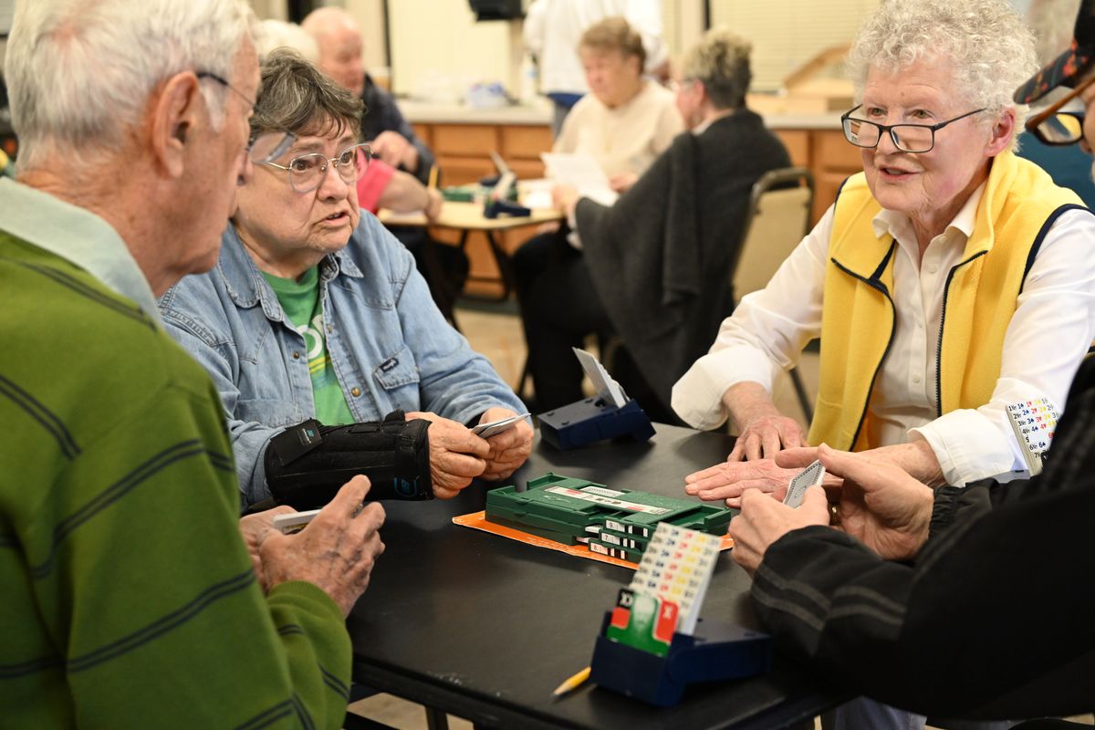 From left, Jim Williams, Jeanne Moore, Catherine Geraghty and Peter Barthels share a couple of observations between hands Friday, April 18, 2025 at the Spokane Duplicate Bridge Club at the Southside Community Center in Spokane, Washington. Although Bridge is supposed to be a quiet game when played, some chat a little between hands.  (Jesse Tinsley/THE SPOKESMAN-REVIEW)