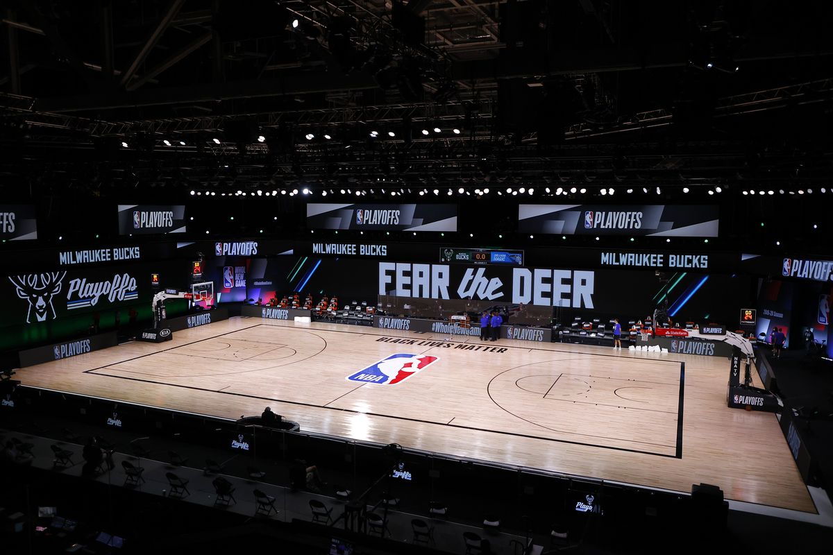 Referees huddle on an empty court at game time of a scheduled game between the Milwaukee Bucks and the Orlando Magic for Game 5 of an NBA basketball first-round playoff series, Wednesday, Aug. 26, 2020, in Lake Buena Vista, Fla.  (Associated Press)