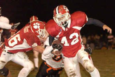 
Sandpoint's Dan Parrish (42), attempting to run around end, has the ball stripped from behind by Post Falls' Shawn Phillips. 
 (Jesse Tinsley / The Spokesman-Review)
