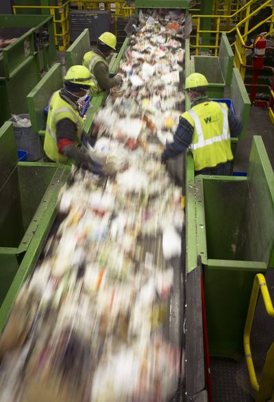 Workers sort newsprint at the Waste Management’s SMaRT Recycling Center on West Plains on Friday. The plant processes more than 6,000 tons of recyclables a month. (Colin Mulvany)
