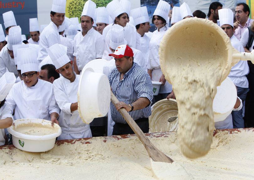 Lebanese chefs prepare a massive bowl of hummus, weighing 22,046 pounds or 10,452 kilograms the size of Lebanon in square kilometers, during a bid to break a record previously held by Israel and reclaim ownership over the popular Middle Eastern dish, in Fanar, east of Beirut, Lebanon, Saturday May 8, 2010. Some 300 Lebanese chefs prepared the huge hummus plate and doubled the record achieved by cooks in an Arab town near Jerusalem in January that weighed around four metric tons and broke a previous record held by Lebanon. A Guinness World Records adjudicator confirmed that Lebanon now holds the record. (Hussein Malla / Associated Press)