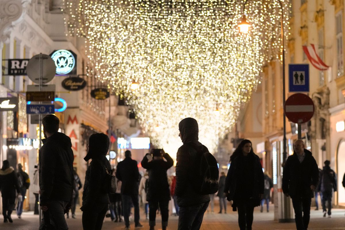 People walk on a street decorated with Christmas lights in Vienna, Austria, Saturday, Nov. 20, 2021. The Austrian government announced a nationwide lockdown that will start Monday and comes as average daily deaths have tripled in recent weeks and hospitals in heavily hit states have warned that intensive care units are reaching capacity. (Vadim Ghirda)