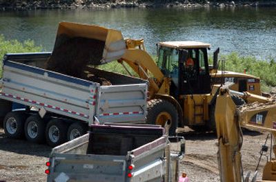 
A front-end loader dumps contaminated soil into a truck at the Starr Road Recreation Area on the Spokane River as cleanup at the site begins Tuesday. 
 (Holly Pickett / The Spokesman-Review)