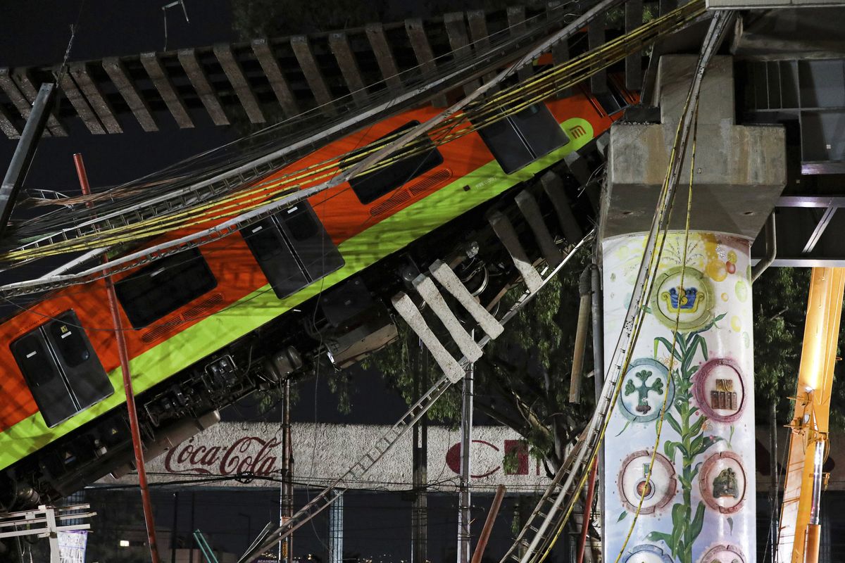 Mexico City's subway cars lay at an angle after a section of Line 12 of the subway collapsed in Mexico City, Tuesday, May 4, 2021. The section passing over a road in southern Mexico City collapsed Monday night, dropping a subway train, trapping cars, and causing at least 50 injuries and several dead, authorities said.  (Marco Ugarte)
