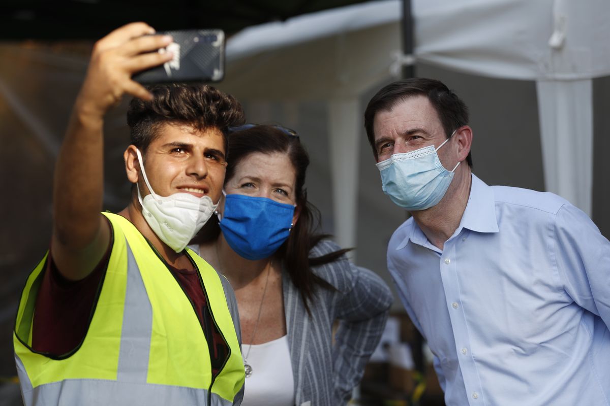 An NGO volunteer, left, takes selfie with U.S. Undersecretary of State for Political Affairs David Hale, right, and U.S. Ambassador to Lebanon Dorothy Shea, center, during their visit to a main gathering point for volunteers near the site of last week