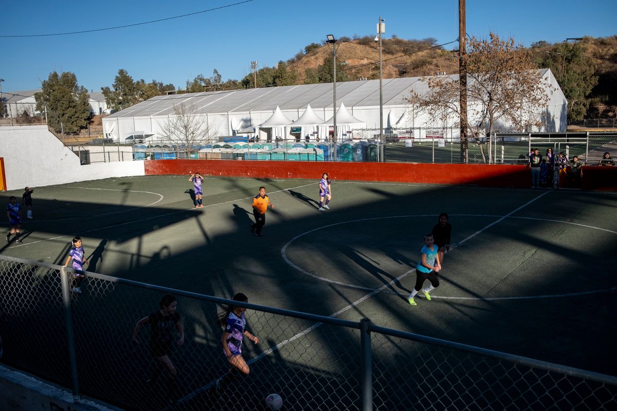 People play soccer near a temporary government shelter in Nogales, Mexico, in February, part of the country’s “Mexico Embraces You” program to receive citizens deported by the United States. (Joel Angel Juarez/For The Washington Post)