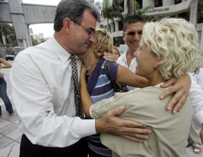 
Ramon Saul Sanchez, left,  is hugged by Rebeca Croes, center, and her twin sister Morelia Croes, right, Thursday in Miami. Twenty-eight Cuban immigrants, including Morelia, were brought to U.S. soil so they can serve as witnesses in a criminal case against the men accused of organizing their deadly smuggling voyage. 
 (Associated Press / The Spokesman-Review)