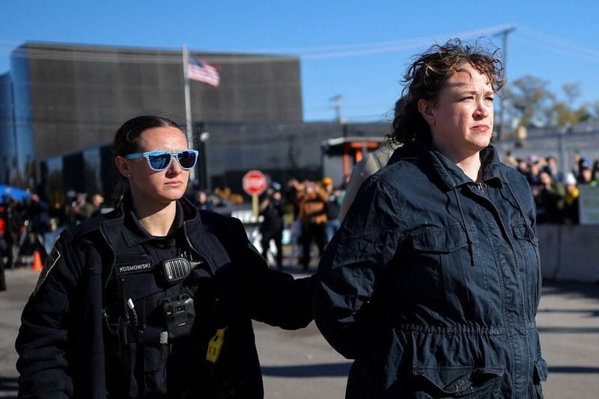 An officer from Broadview Police Department detains a woman during a protest against immigration actions, outside the Broadview ICE facility in Chicago, Illinois, U.S., November 7, 2025. REUTERS/Carlos Barria (Carlos Barria)