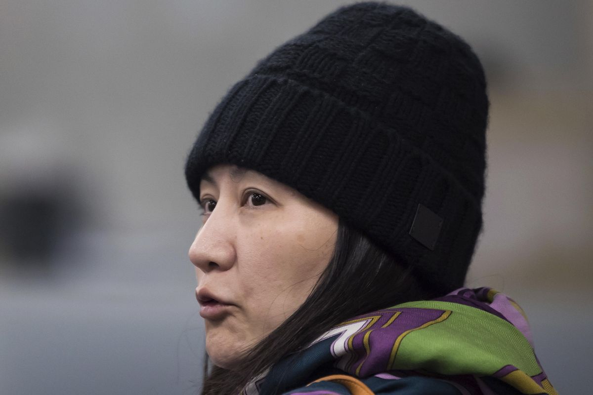 Huawei chief financial officer Meng Wanzhou talks with a member of her private security detail after they went into a wrong building while arriving at a parole office in Vancouver, British Columbia, on Wednesday, Dec. 12, 2018. (Darryl Dyck / AP)