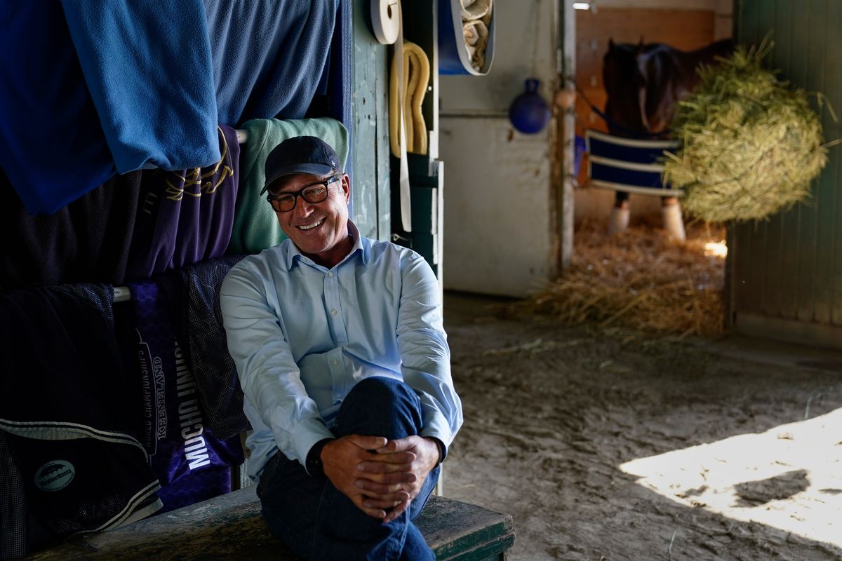 Tim Yakteen smiles in his horse barn at Santa Anita Park on Monday, April 25, 2022, in Arcadia, Calif. He will saddle two horses - Messier and Taiba, both formerly trained by Bob Baffert - for the Kentucky Derby. Baffert is serving a 90-day suspension from horse racing.  (Ashley Landis)