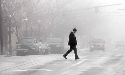 
A pedestrian walks through the fog while crossing Sherman Avenue in Coeur d'Alene on Wednesday. 
 (Kathy Plonka / The Spokesman-Review)